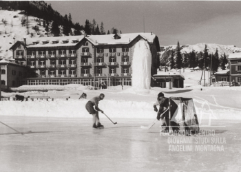 Lago di Misurina ghiacciato, con giocatori di Hockey e sullo sfondo il Grand Hotel Misurina. Anni '60.