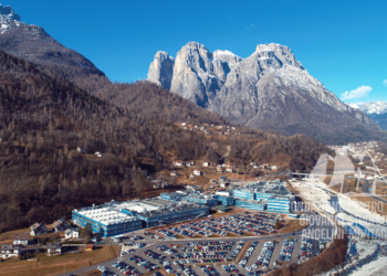 Agordo, in primo piano la sede della Luxottica, e i danni provocati dalla tempesta Vaia sul versante soprastante.